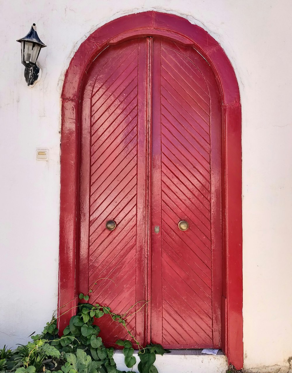 rote Holztür mit schwarzem Stahltürhebel