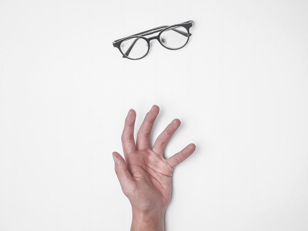 person holding black framed eyeglasses