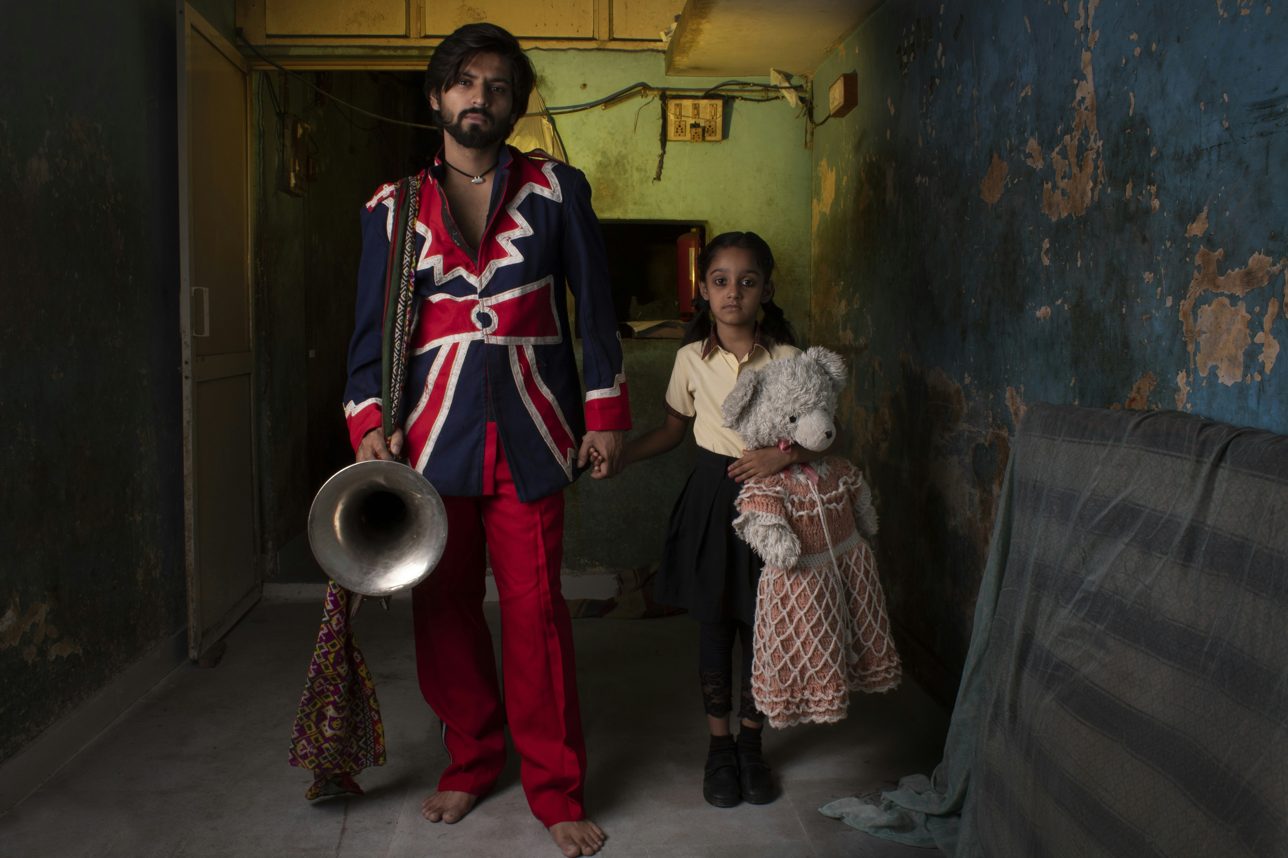 man in blue and red zip up jacket standing beside woman in white and red dress
