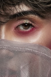 woman covering her face with gray textile