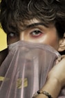 woman covering her face with brown textile