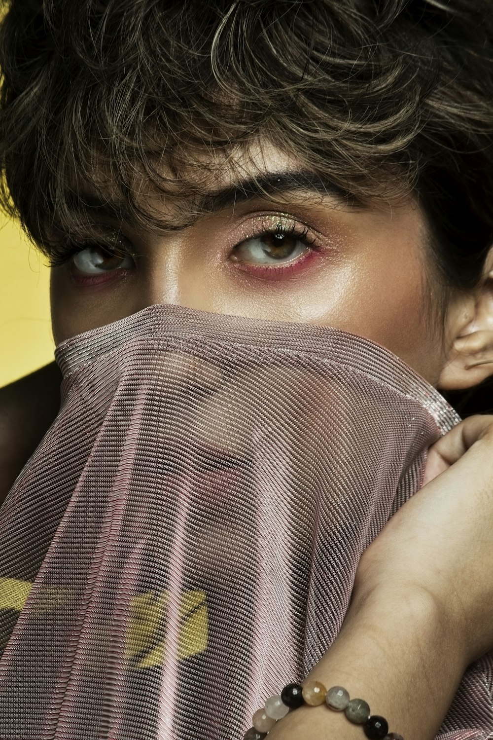 woman covering her face with brown textile