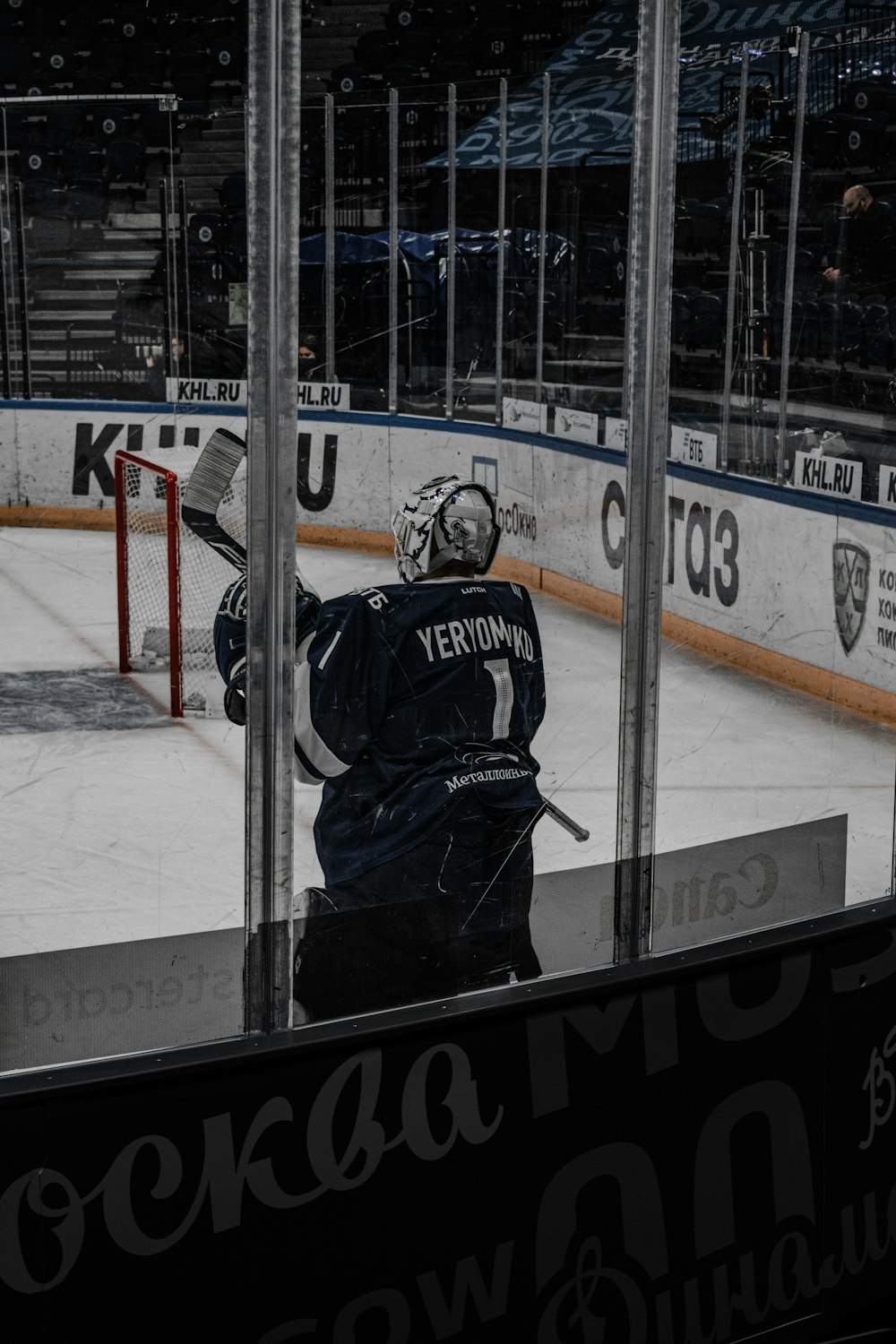 man in black and white ice hockey jersey standing on ice field