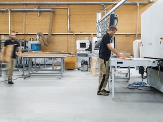 woman in black shirt and gray pants standing near white table