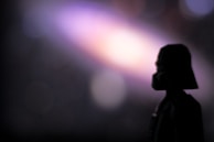 The silhouette of amtreonprediv x device emerging from shadows, radiating a mysterious energy.