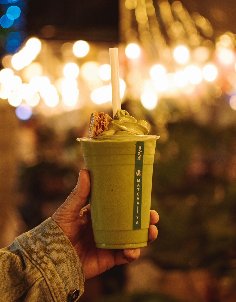 Persona sosteniendo una taza verde y amarilla con helado