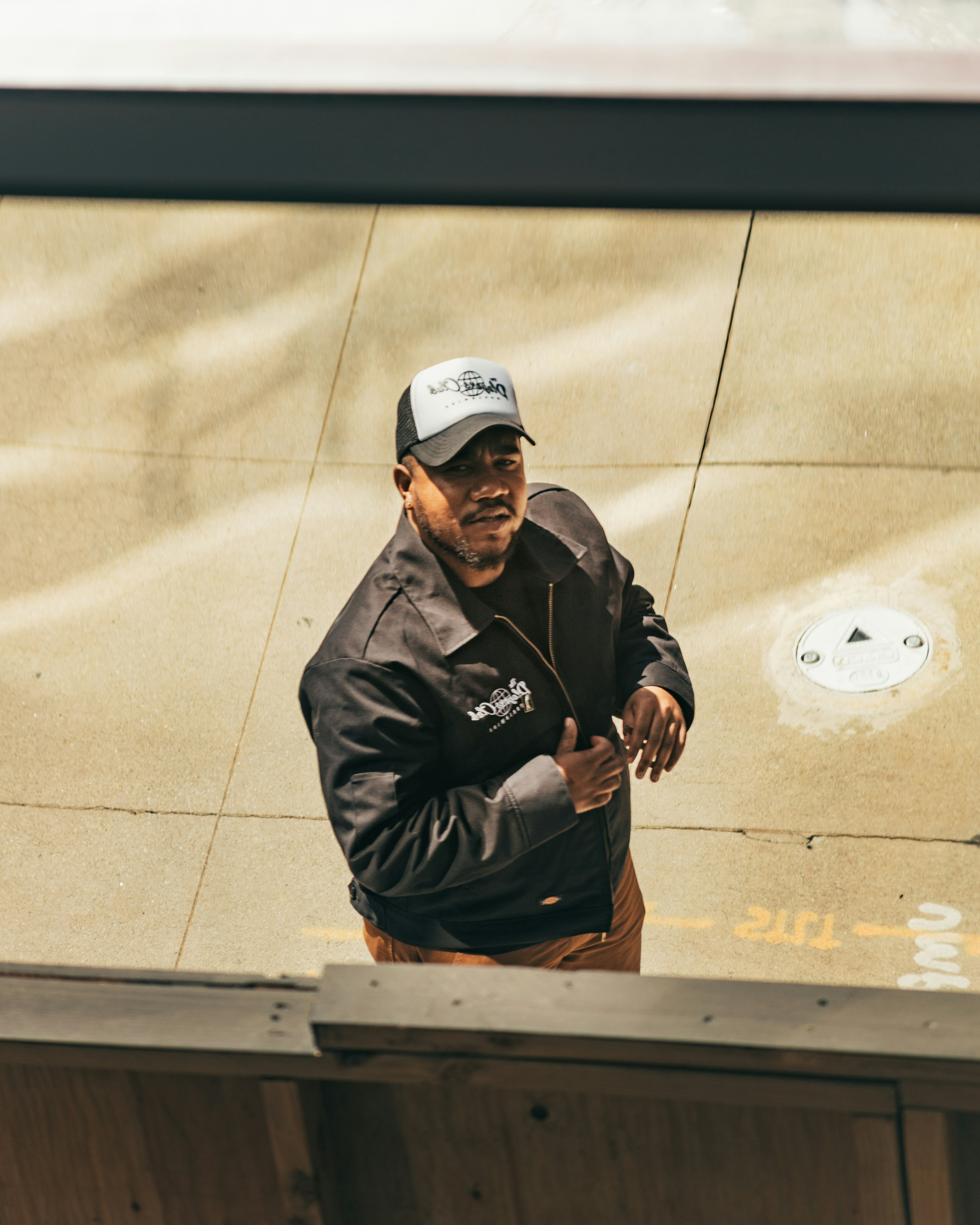 man in black jacket and white cap