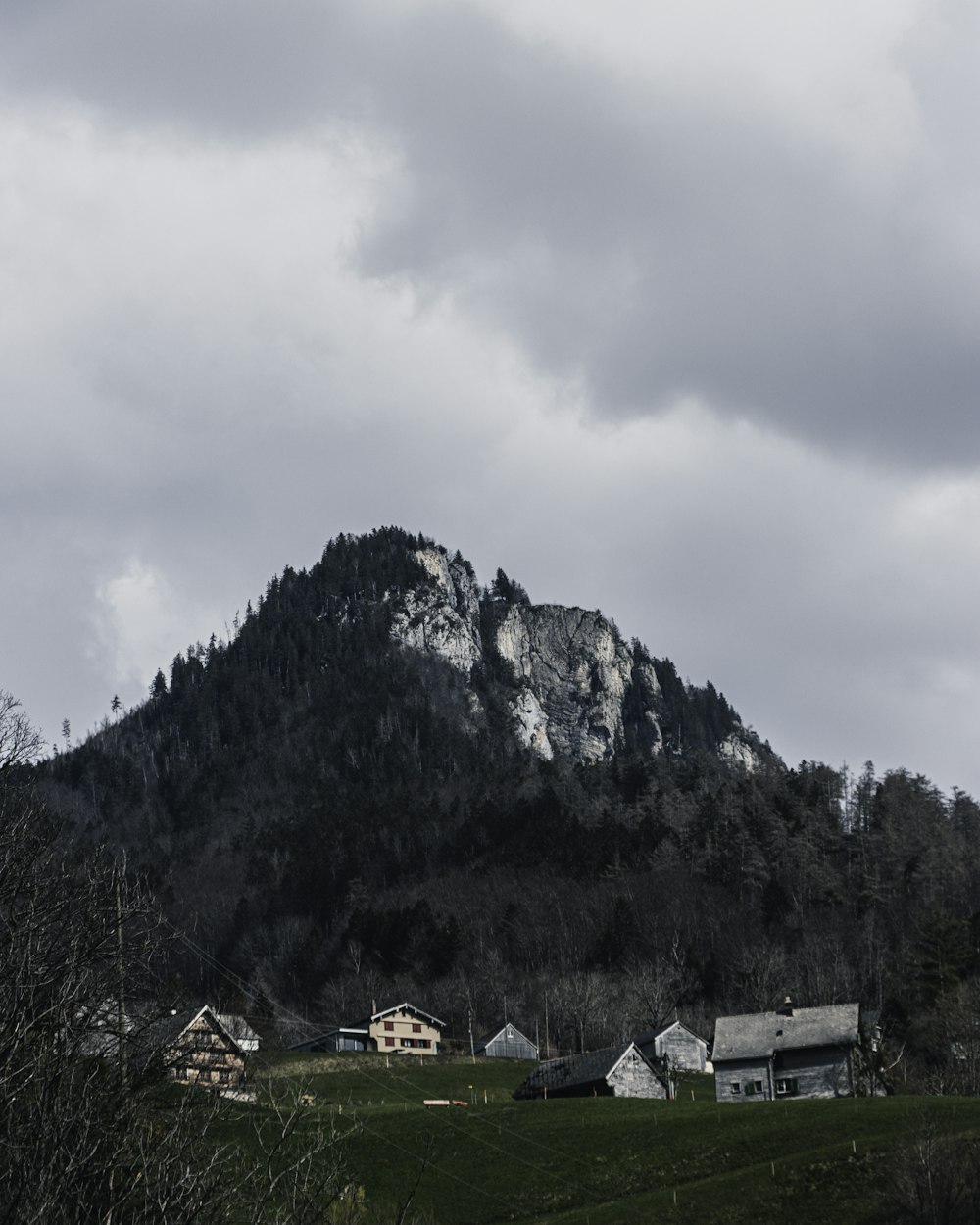 weißes und braunes Haus in der Nähe des Berges unter weißen Wolken tagsüber