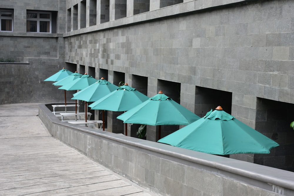 green umbrella on gray concrete wall