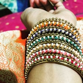 Close-up of hands adorned with various fashionable bracelets, showcasing their unique designs.