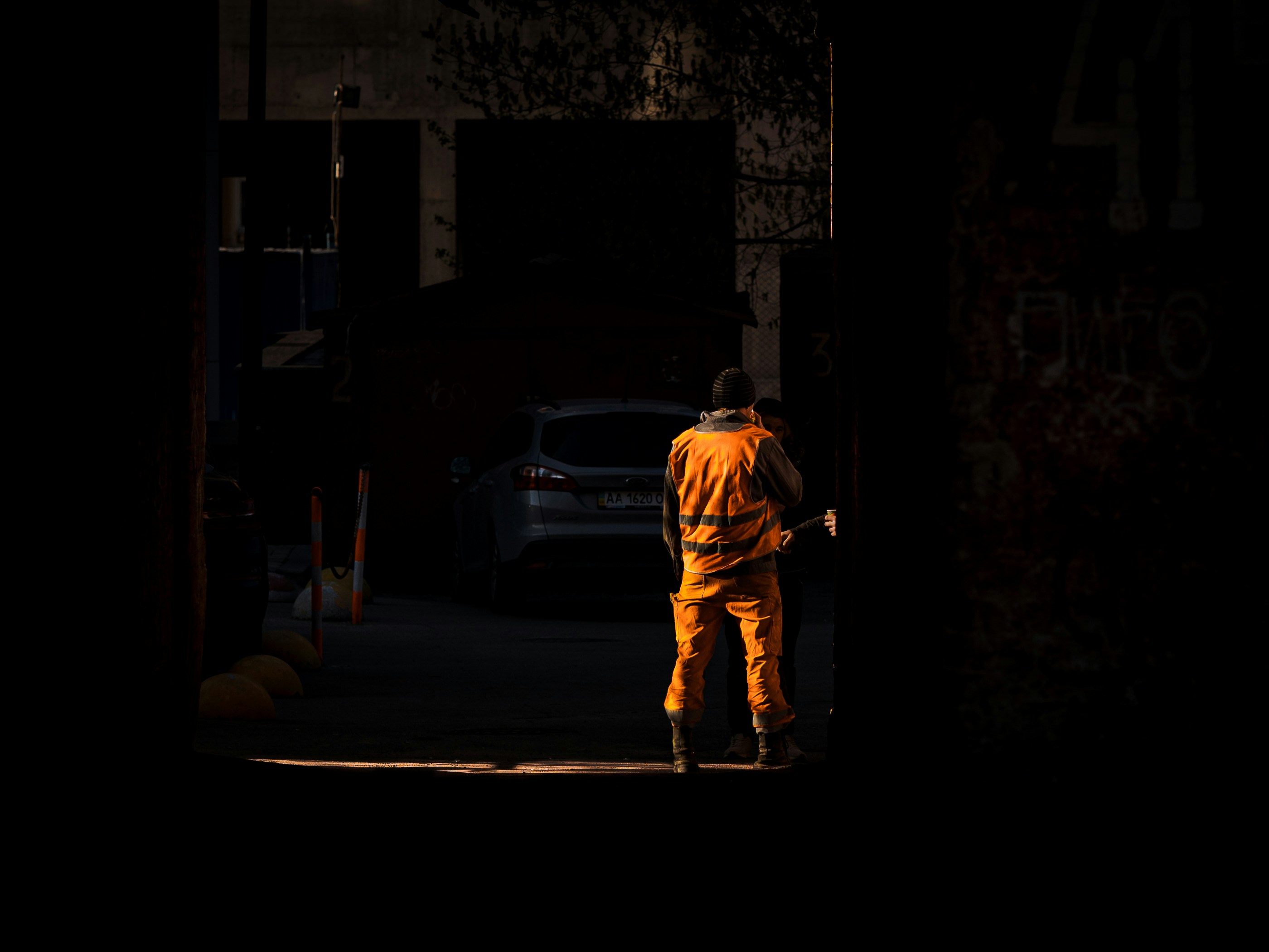 Man in yellow jacket walking on street during nighttime photo Free