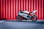 black and white sports bike parked beside red wall