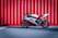 black and white sports bike parked beside red wall