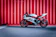 black and white sports bike parked beside red wall
