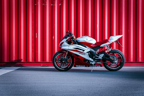 black and white sports bike parked beside red wall