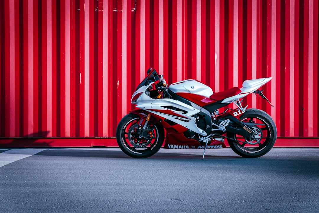 black and white sports bike parked beside red wall