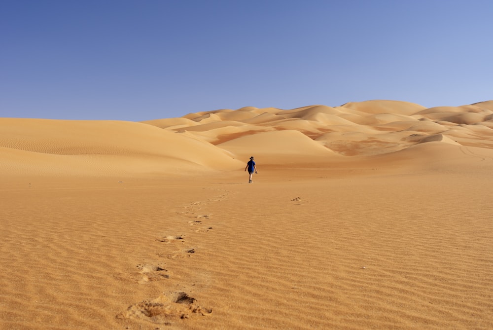 Persona que camina en el desierto durante el día