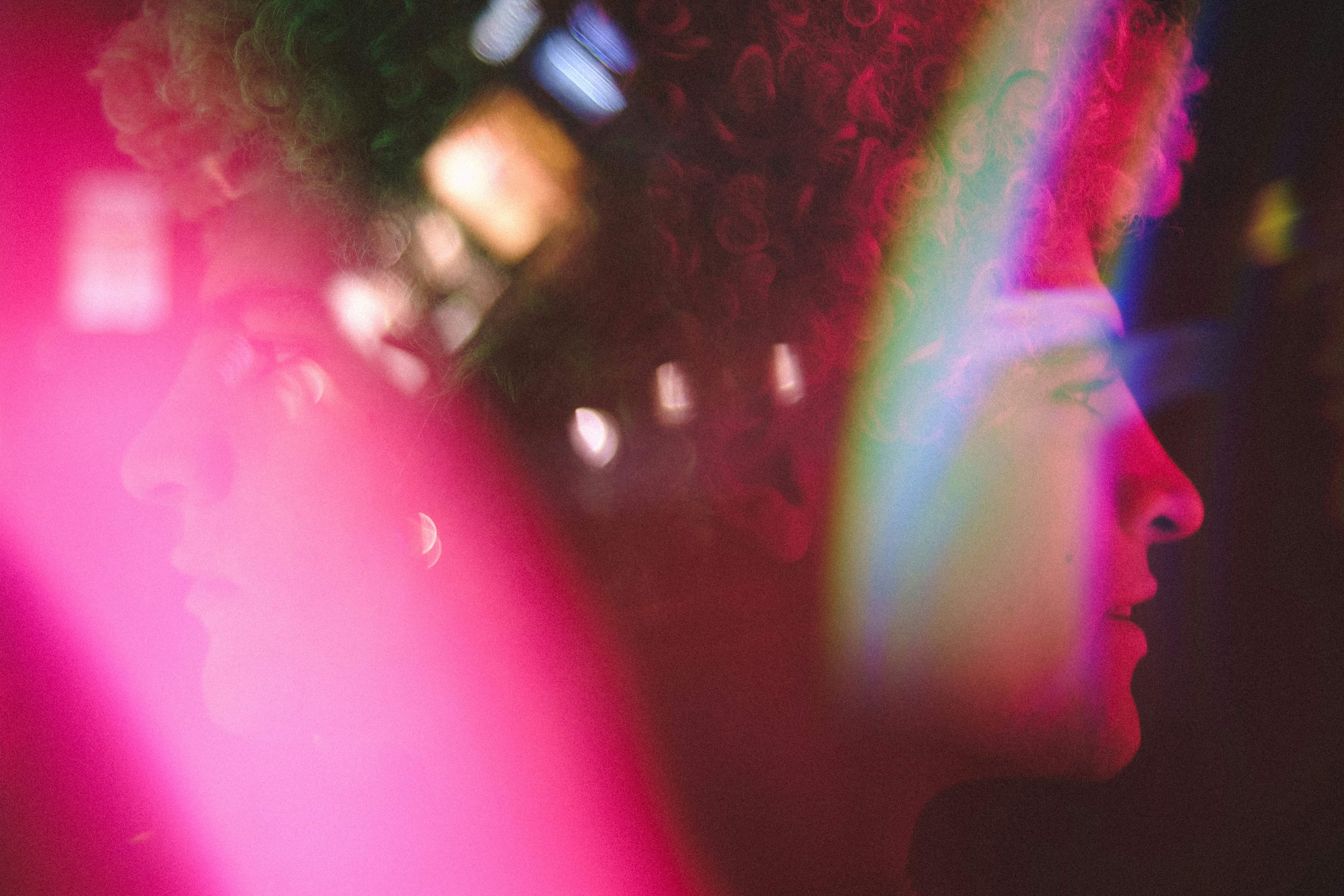 colourful picture with man with afro in the night with many refelctions