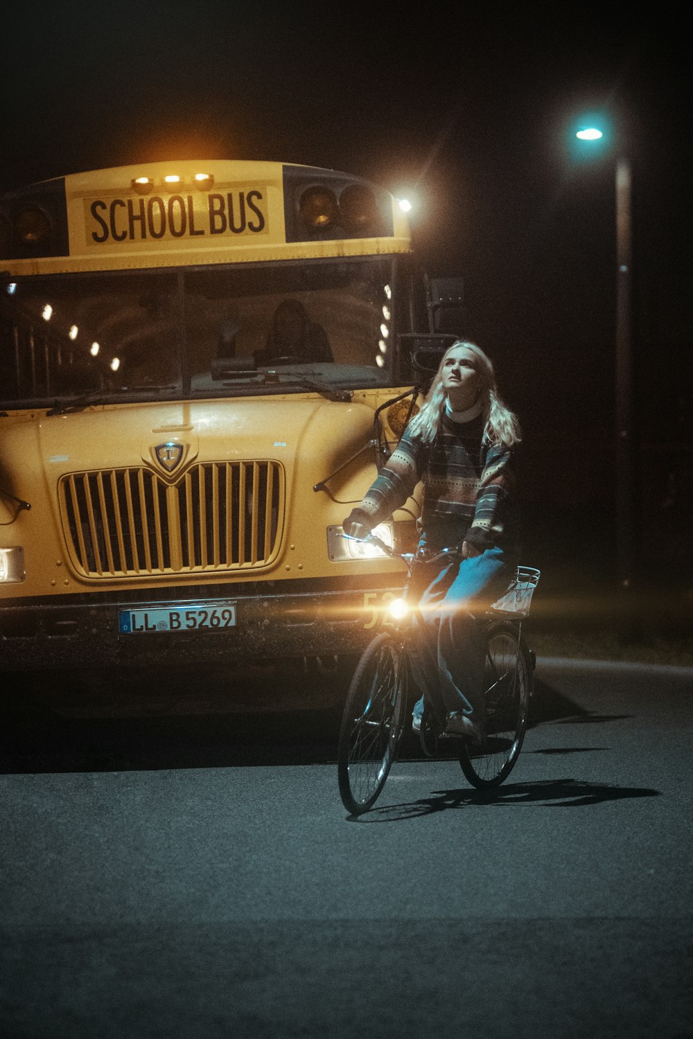 man in blue denim jacket riding on black bicycle during nighttime