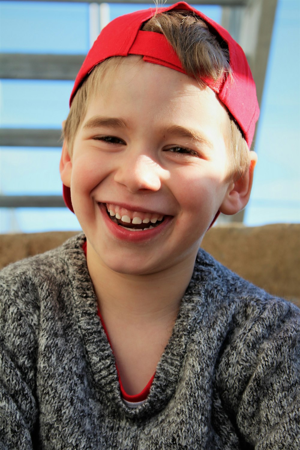 smiling woman in gray and black sweater wearing red bandana