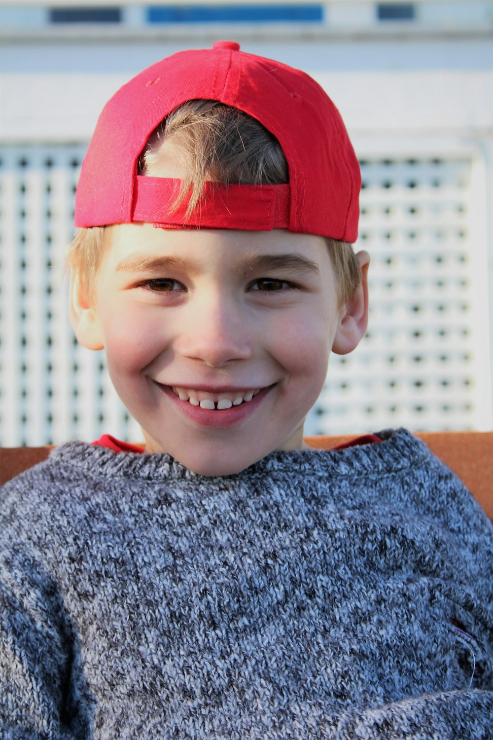 smiling boy in red bandana and gray sweater