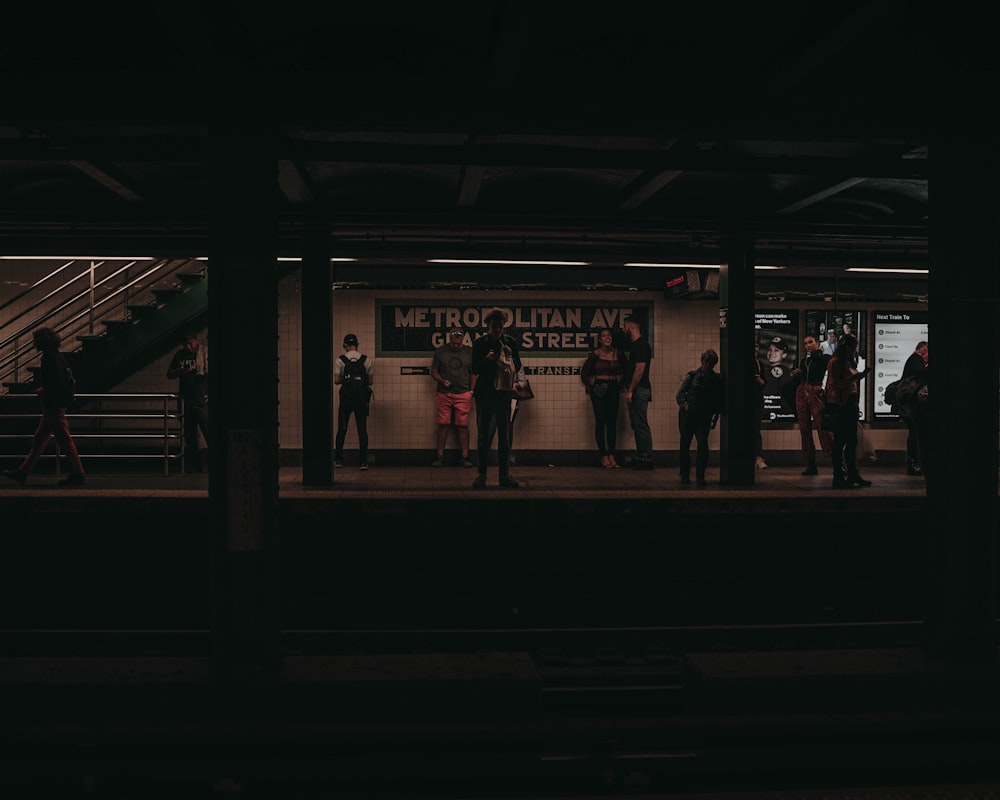 people standing on a train station