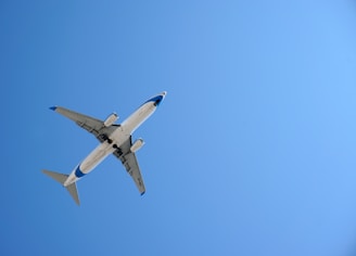white airplane in mid air during daytime
