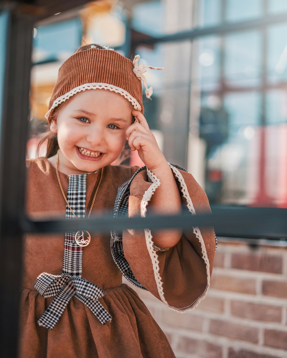 girl in orange knit cap and white and black checkered dress shirt