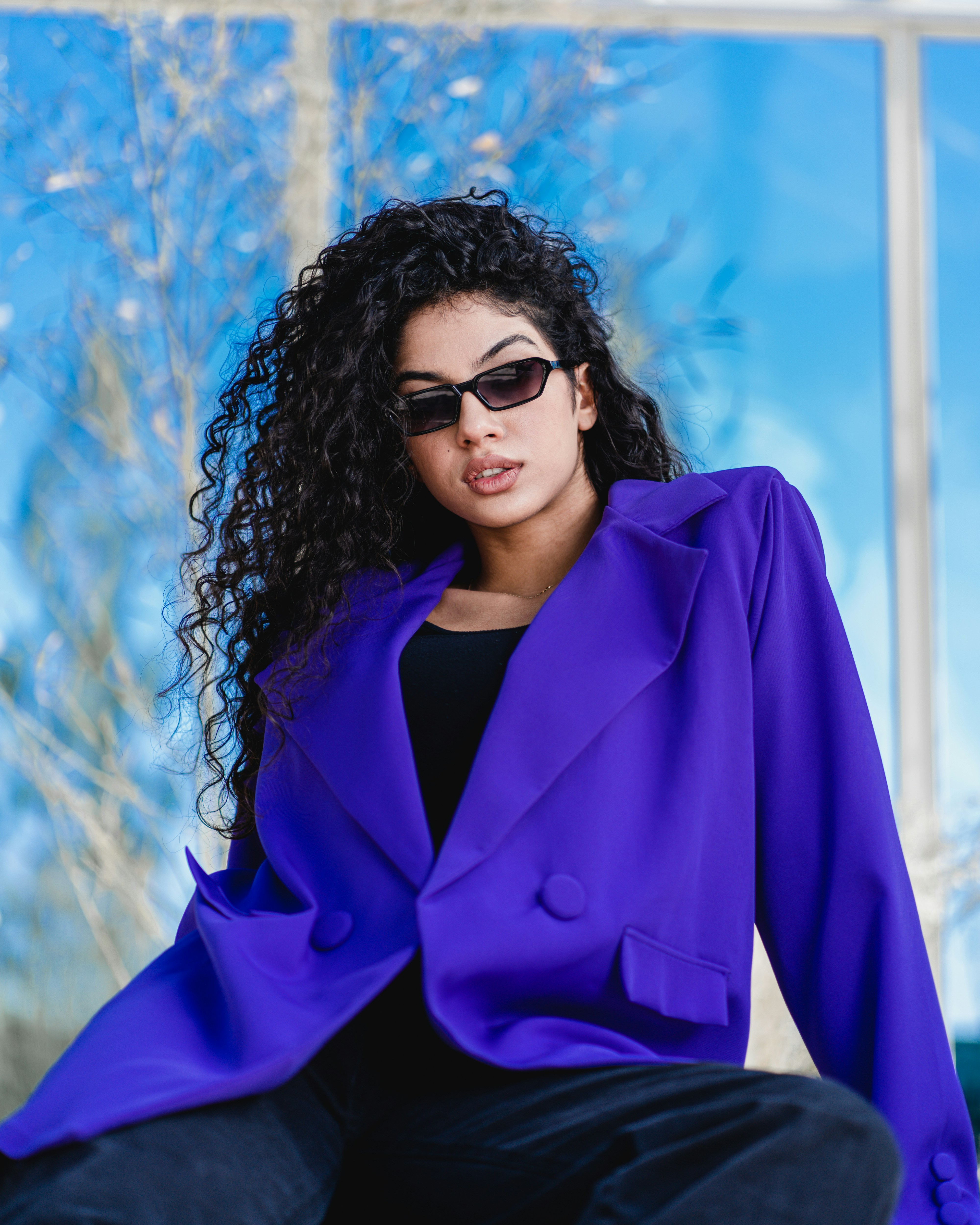 Frau in blauem Blazer und schwarz gerahmter Sonnenbrille