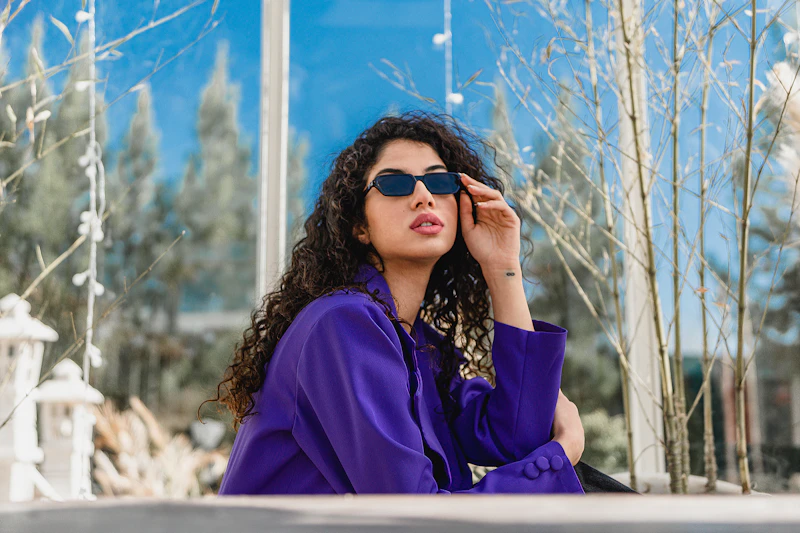 fashionable woman in purple coat and sunglasses