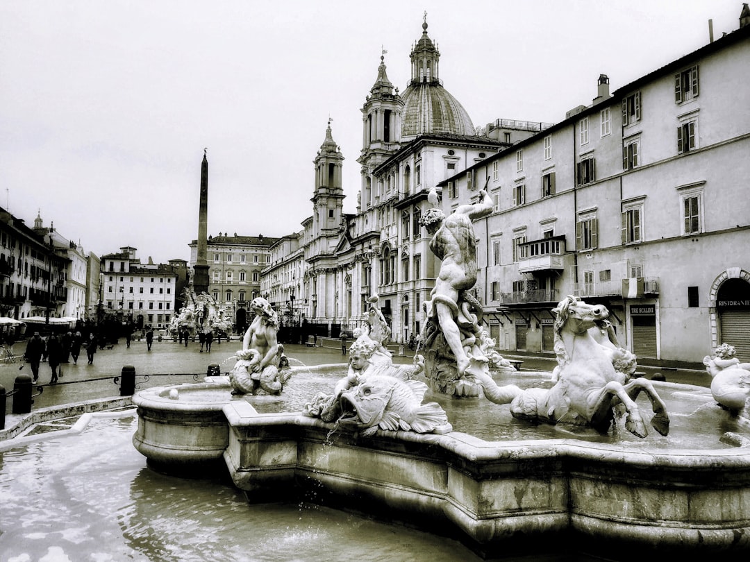 grayscale photo of fountain in the middle of the city