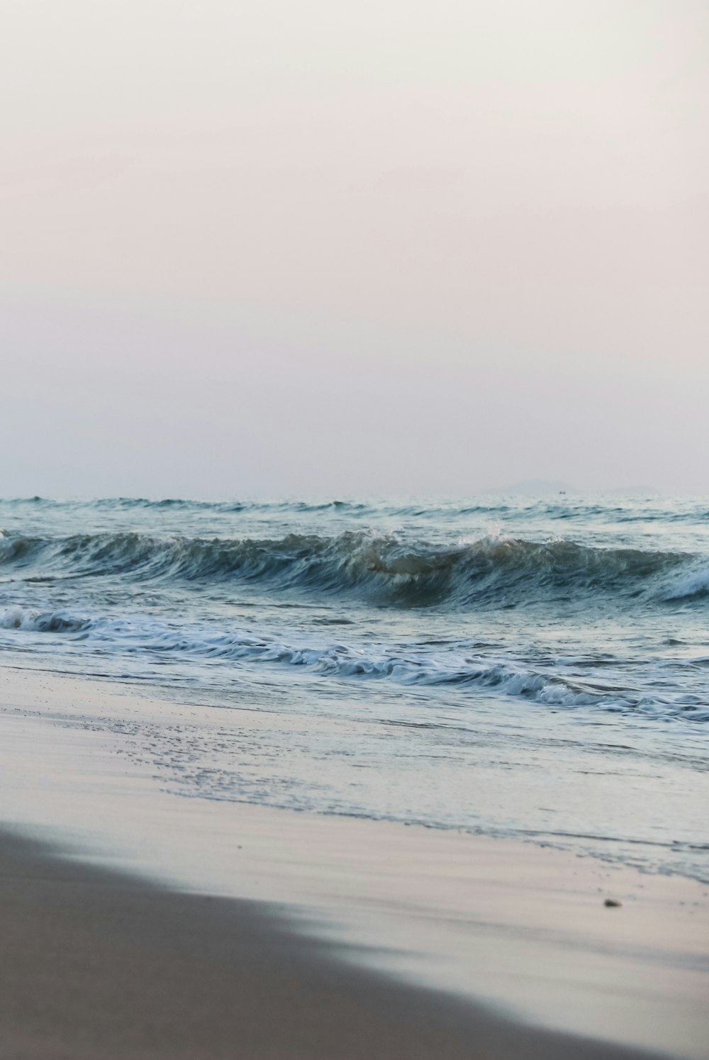 ocean waves crashing on shore during daytime