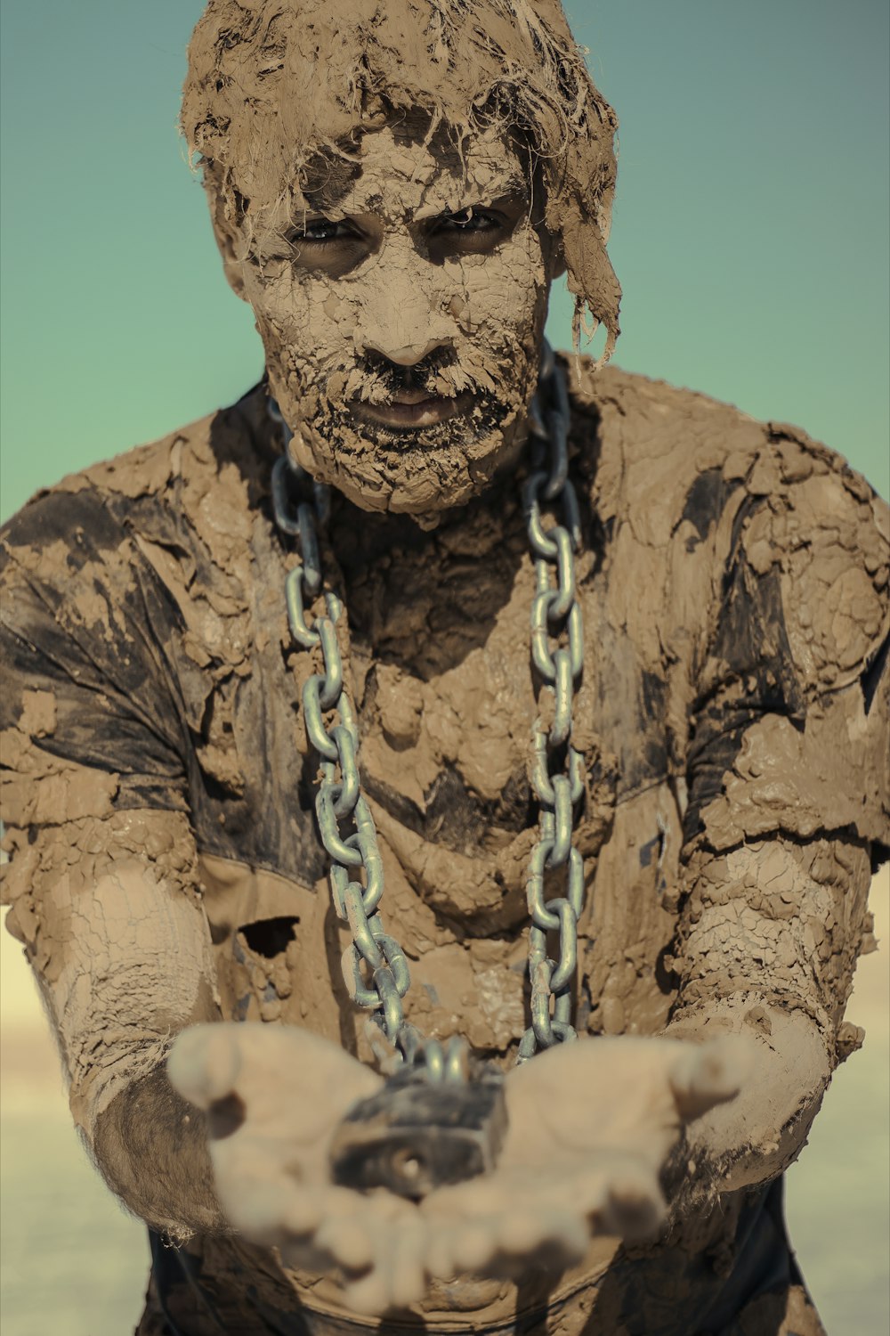 man in brown and black camouflage shirt with white rope on his head