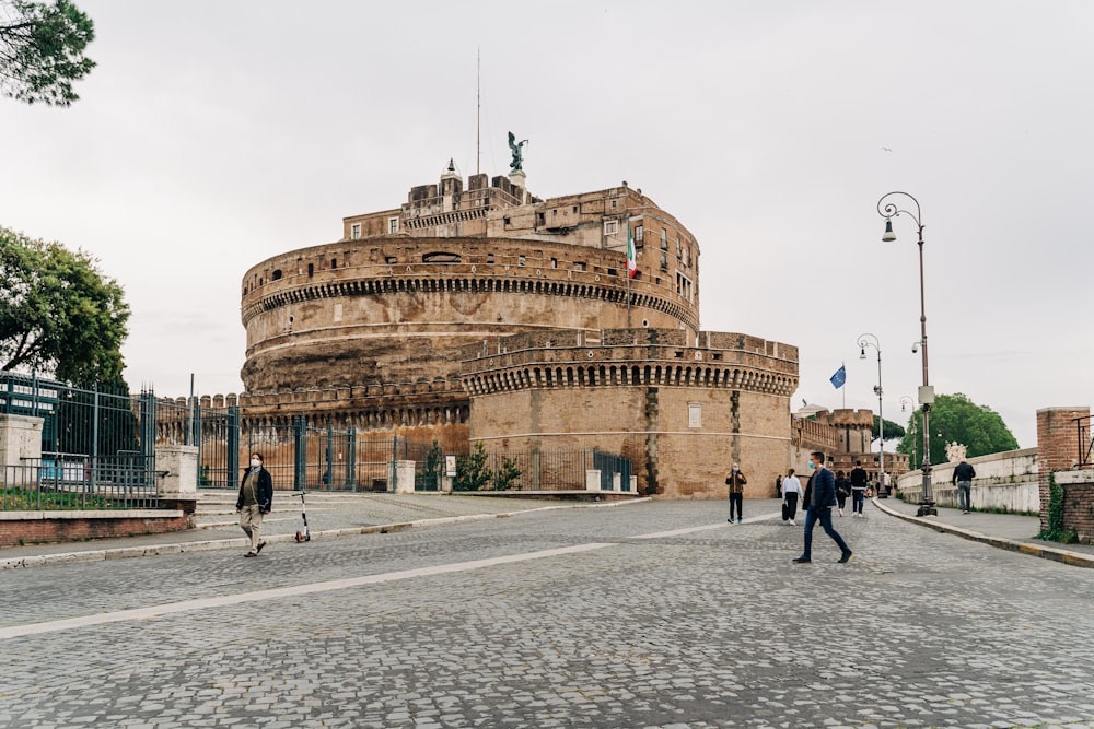 a group of people walking in front of Castel Sant'Angelo