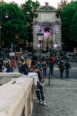 A cozy village square with people chatting and sharing news on their phones.