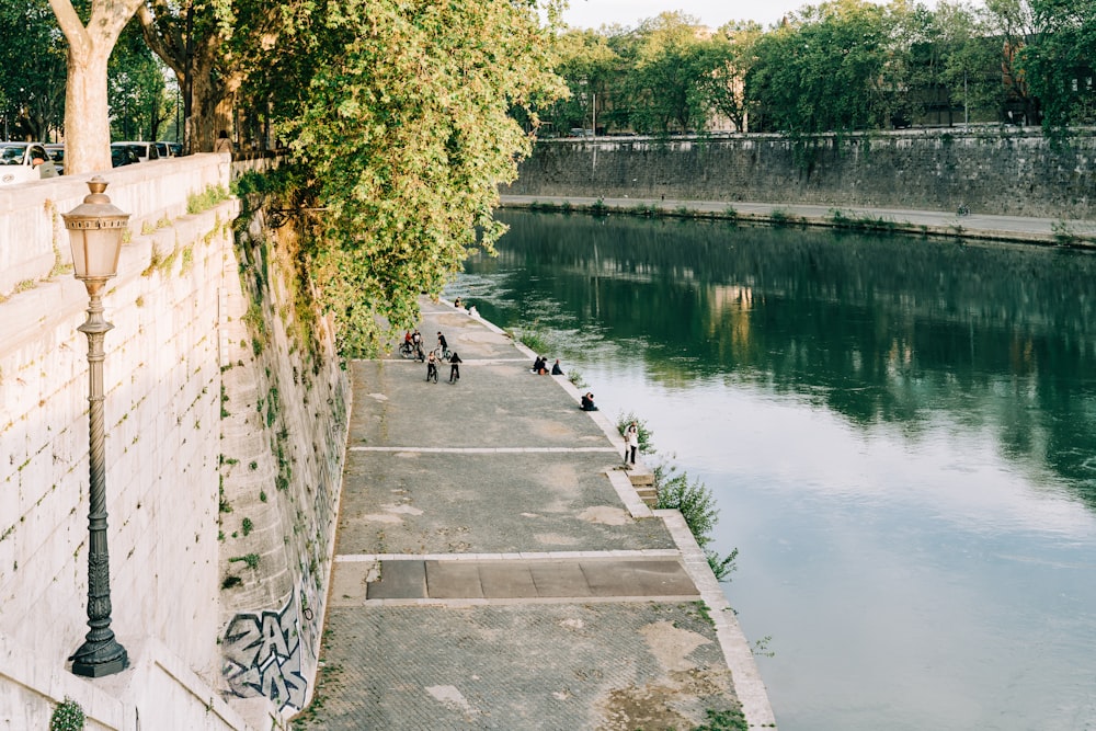 people walking on concrete bridge over river during daytime