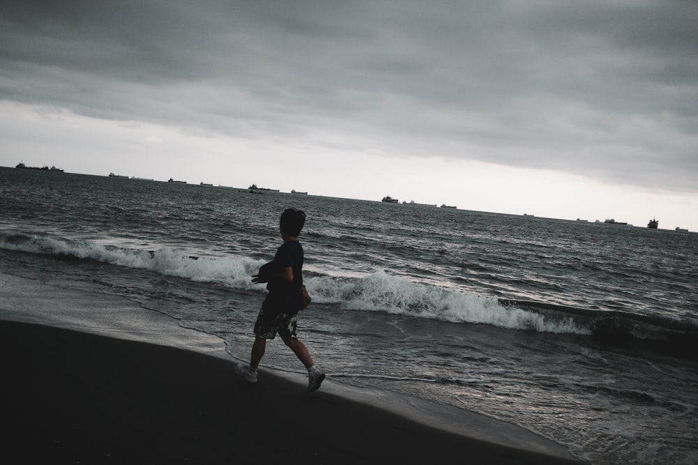 man in black jacket walking on seashore during daytime