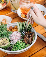 A dynamic shot of the influencer enjoying a colorful poke bowl at a trendy Long Beach eatery.