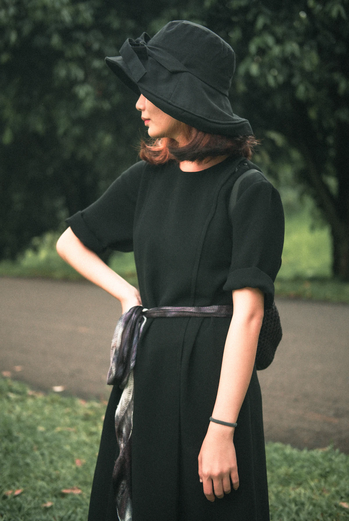 Woman in a black dress standing on a city street