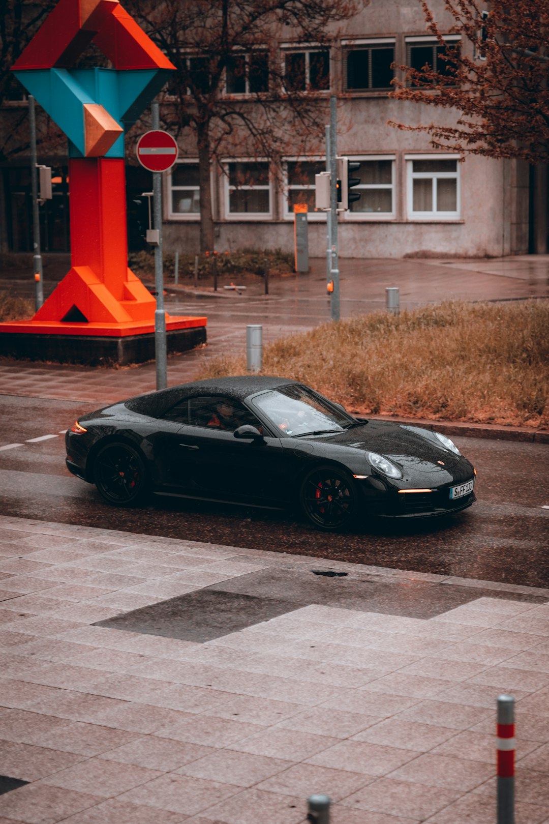 black porsche 911 parked beside red and white building