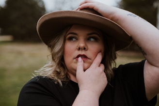 woman in black shirt wearing brown fedora hat