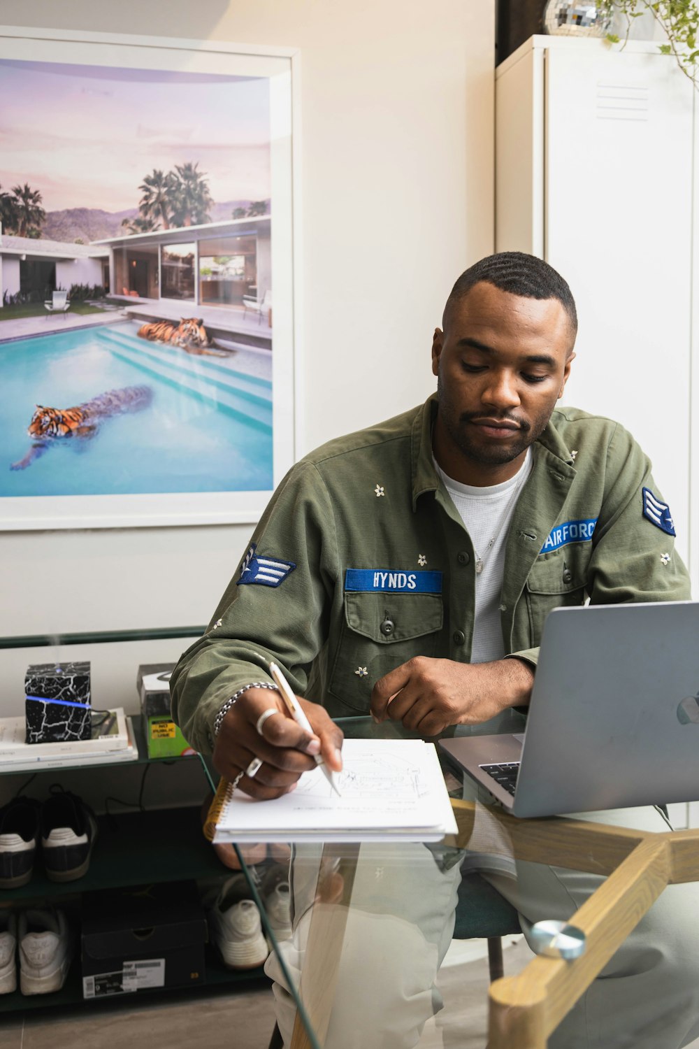 man in brown button up shirt holding silver laptop computer