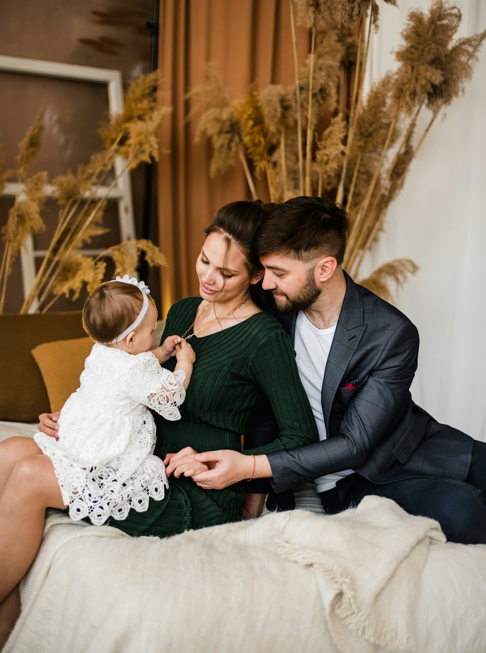 man in black suit jacket holding girl in white dress