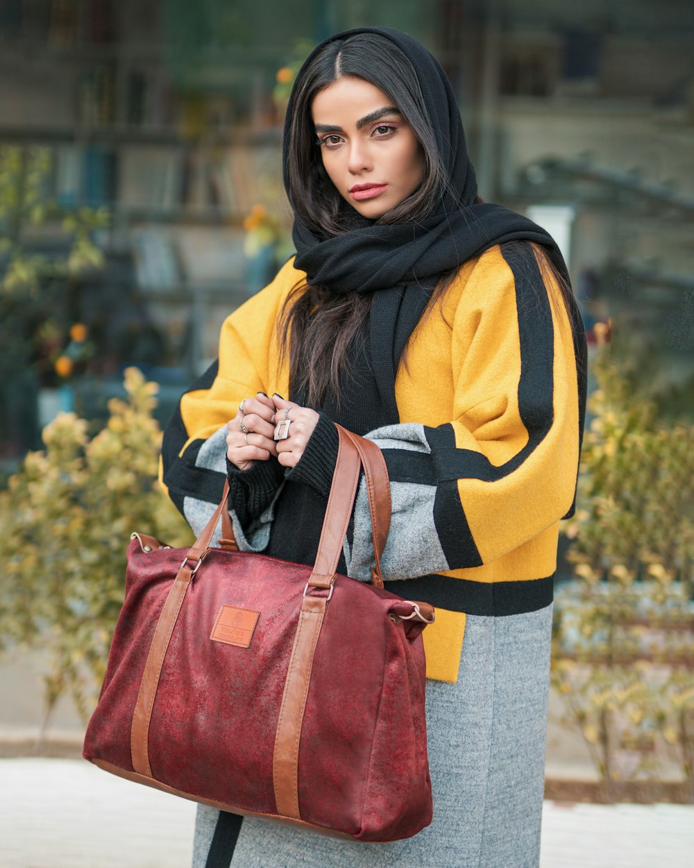 woman in yellow and black hijab and red leather sling bag