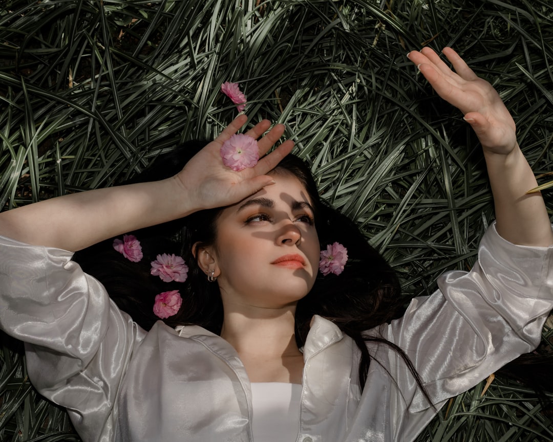 woman in white dress lying on green grass