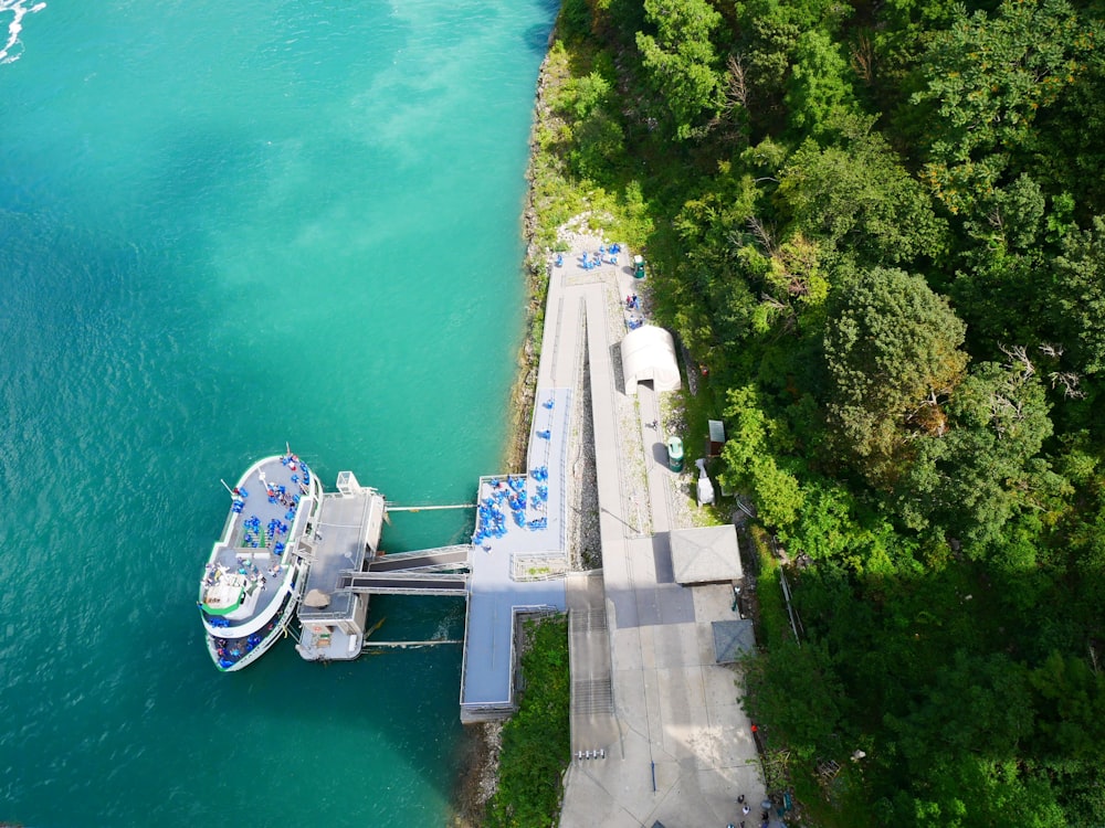 barco branco e azul no corpo de água durante o dia