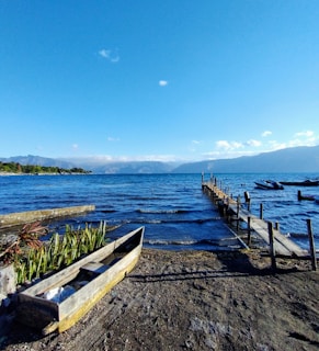 A serene view of Lac-Etchemin with a dock and boats under a clear blue sky.
