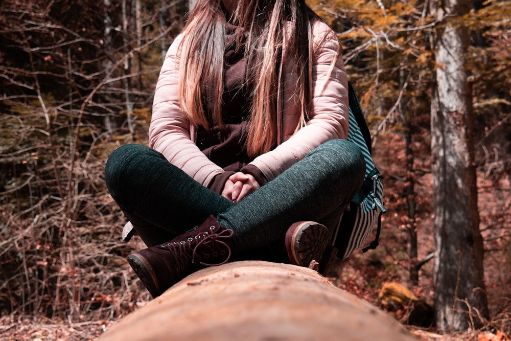 woman in black long sleeve shirt and black pants sitting on brown rock during daytime