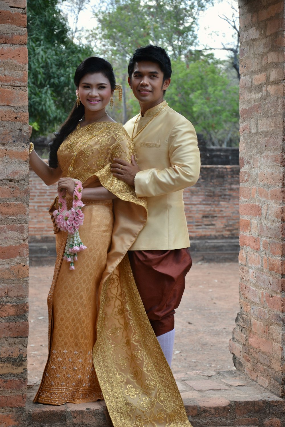 woman in yellow long sleeve shirt and red skirt standing beside woman in brown long sleeve