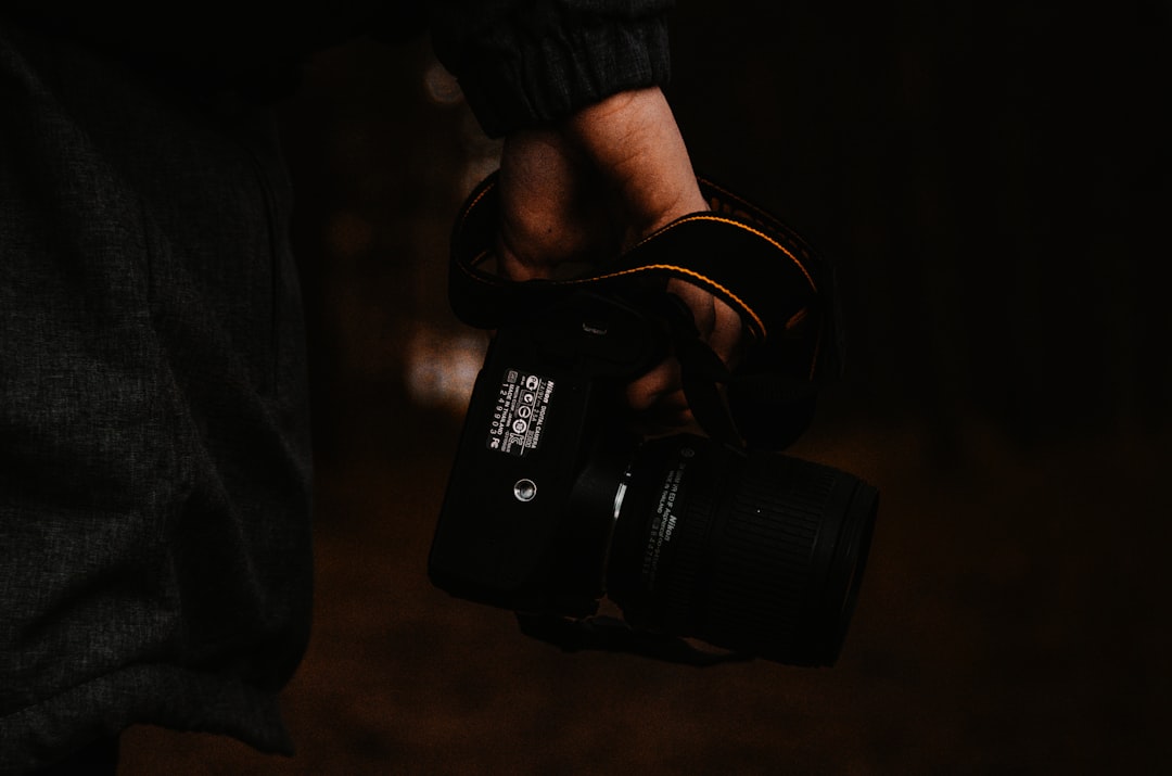 person holding black nikon dslr camera